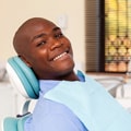 A man wearing a bib sitting in a dental chair
